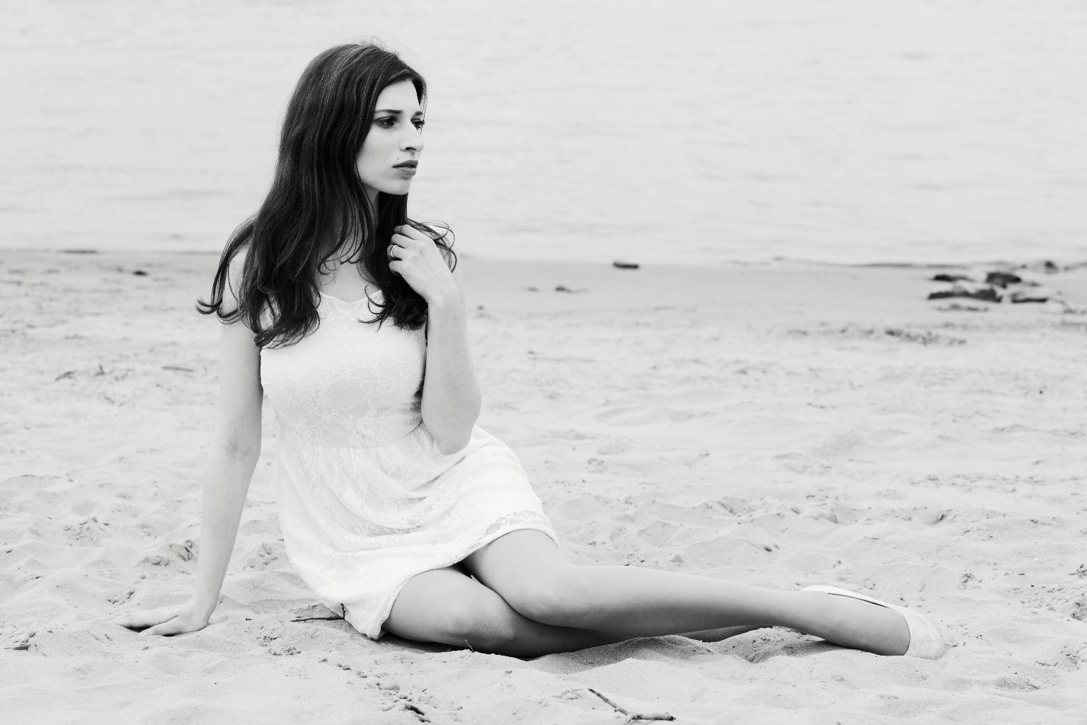 Model sitzend am Strand