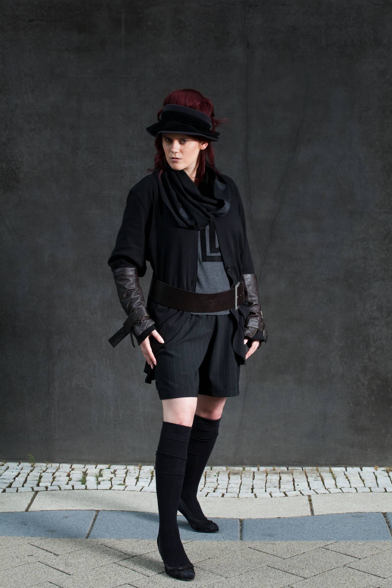 Model in schwarzem Outfit, kurze Hose, Kappe